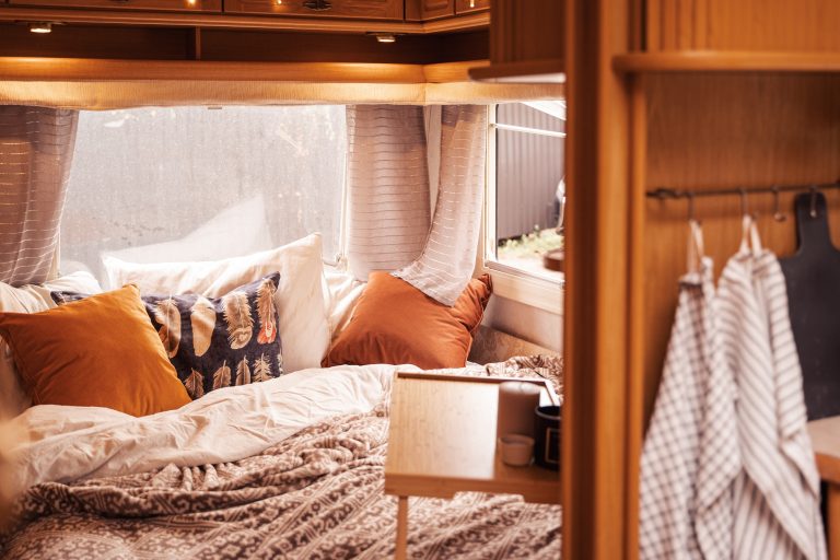 Cozy bedroom nook in wooden camper interior