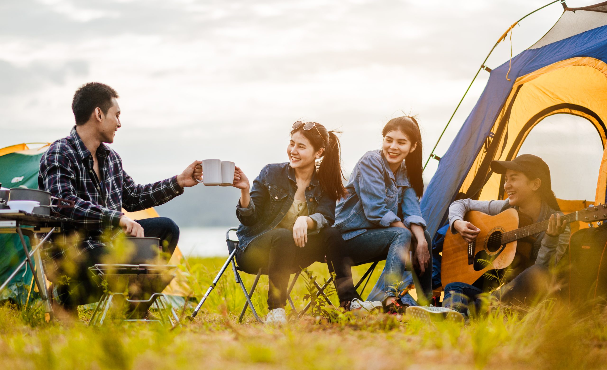 Friends camping together by the lake having fun