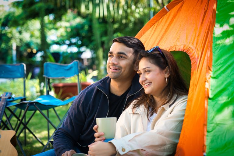Smiling couple relaxing outside their tent